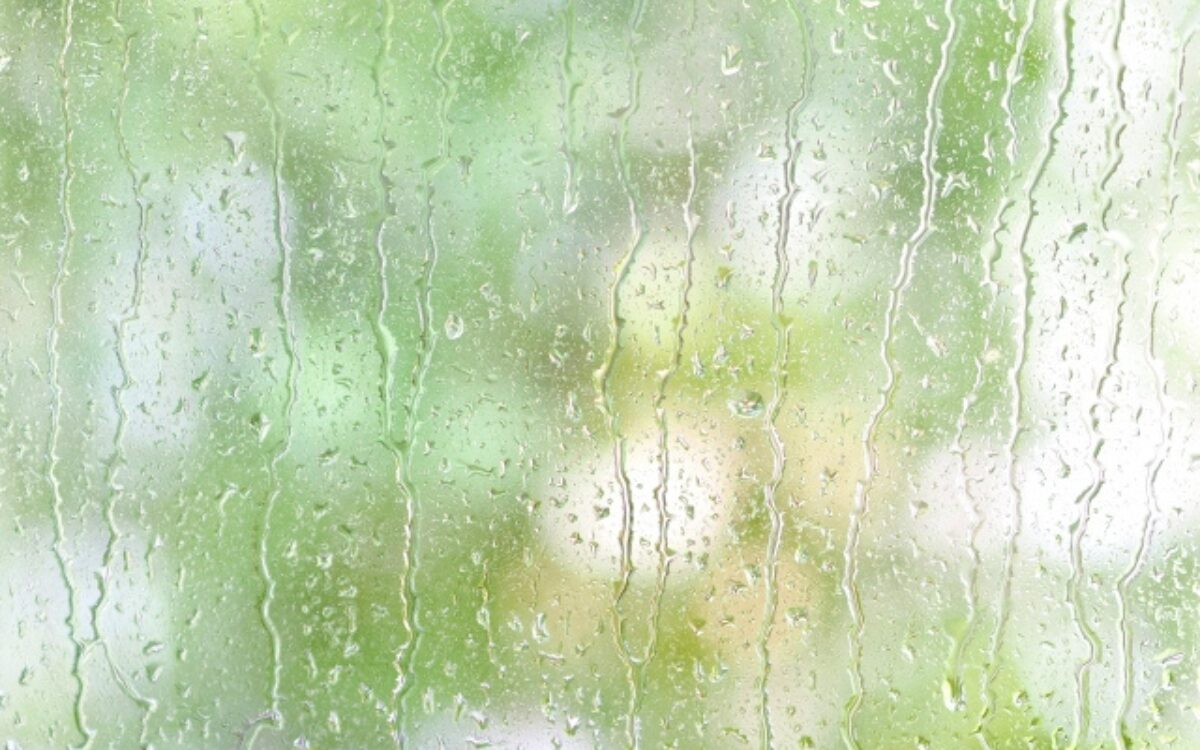 雨のしずくが流れる窓辺の風景。不倫のフラッシュバックで苦しい心の停滞感